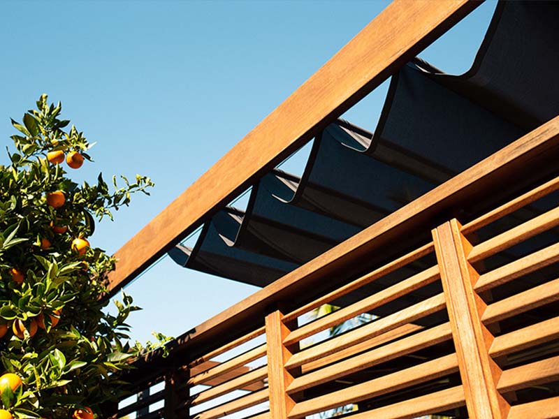 retractable shade sail extends and retracts along stainless steel cables protecting outdoor areas from UV rays and heat