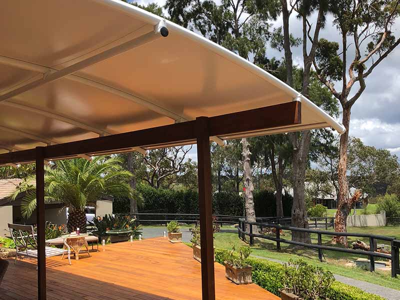 Fixed curved shade sail roof on timber pergola