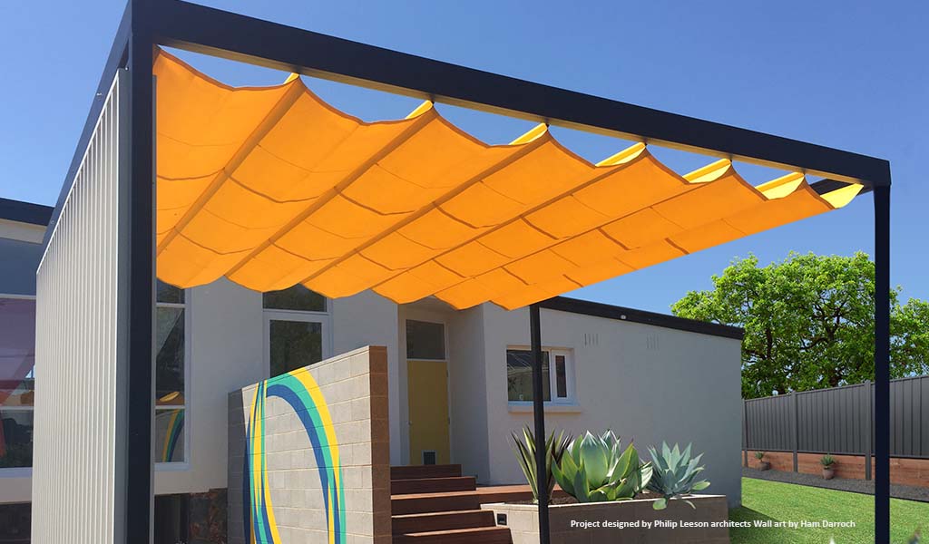 Bright Yellow retractable shade sail over free stading cabana