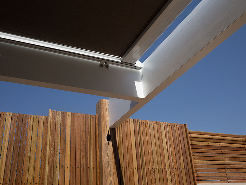 Retractable conservatory patio awning over outdoor living area