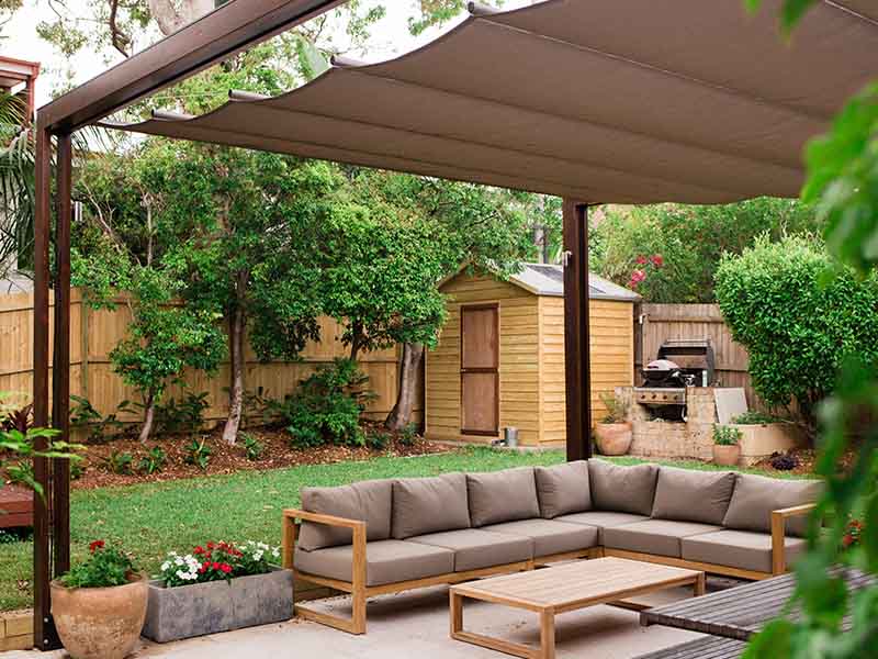 Retractable shade sail over outdoor space to provide sun protection